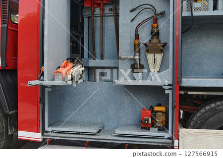 Close-up of essential firefighting equipment on a modern firetruck, showcasing tools and gear ready for emergency response to hazardous fire situations Close-up of essential firefighting equipment on a modern firetruck, showcasing tools and gear ready for emergency response to hazardous fire situations 127566915