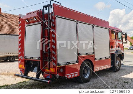 A state-of-the-art firetruck, equipped with advanced rescue technology, stands ready with its skilled firefighting team, prepared to intervene and respond rapidly to emergencies, ensuring the safety 127566920