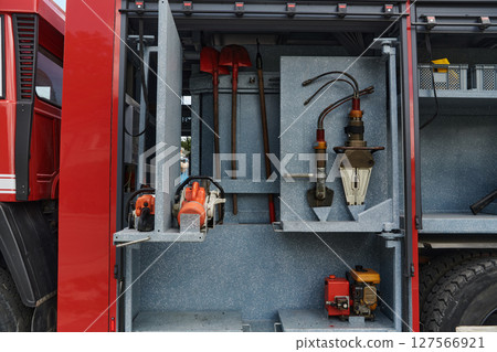 Close-up of essential firefighting equipment on a modern firetruck, showcasing tools and gear ready for emergency response to hazardous fire situations Close-up of essential firefighting equipment on a modern firetruck, showcasing tools and gear ready for emergency response to hazardous fire situations 127566921