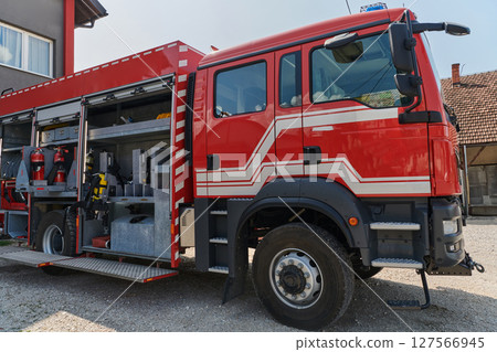 A state-of-the-art firetruck, equipped with advanced rescue technology, stands ready with its skilled firefighting team, prepared to intervene and respond rapidly to emergencies, ensuring the safety 127566945