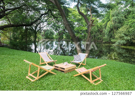 bedchair and table on green greenery garden by pond of cafe bedchair and table on green greenery garden by pond of cafe 127566987