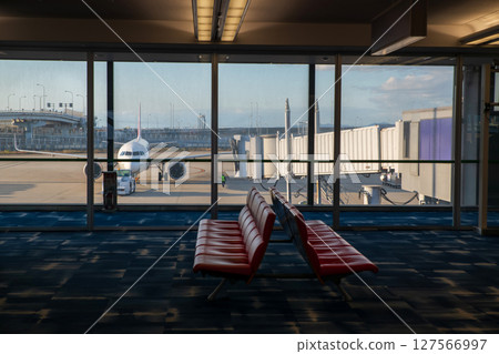 Waiting seats at departure terminal with airplane in runway 127566997