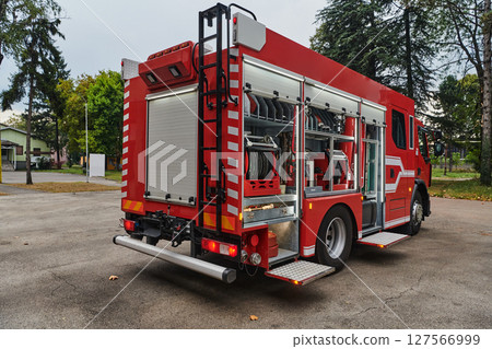 A state-of-the-art firetruck, equipped with advanced rescue technology, stands ready with its skilled firefighting team, prepared to intervene and respond rapidly to emergencies, ensuring the safety A state-of-the-art firetruck, equipped with advanced rescue technology, stands ready with its skilled firefighting team, prepared to intervene and respond rapidly to emergencies, ensuring the safety 127566999