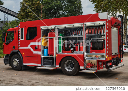 A state-of-the-art firetruck, equipped with advanced rescue technology, stands ready with its skilled firefighting team, prepared to intervene and respond rapidly to emergencies, ensuring the safety 127567010