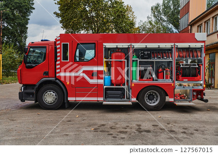 A state-of-the-art firetruck, equipped with advanced rescue technology, stands ready with its skilled firefighting team, prepared to intervene and respond rapidly to emergencies, ensuring the safety 127567015
