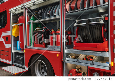 A state-of-the-art firetruck, equipped with advanced rescue technology, stands ready with its skilled firefighting team, prepared to intervene and respond rapidly to emergencies, ensuring the safety 127567018