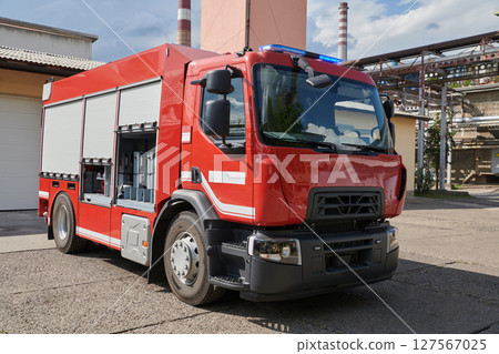 A state-of-the-art firetruck, equipped with advanced rescue technology, stands ready with its skilled firefighting team, prepared to intervene and respond rapidly to emergencies, ensuring the safety 127567025