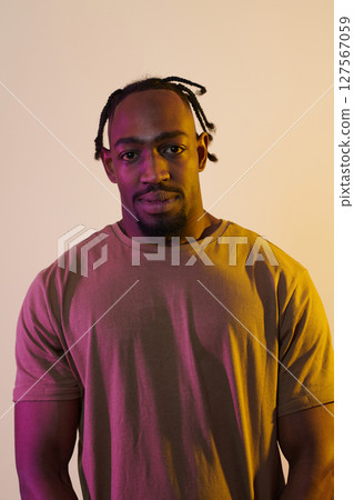 A charismatic and stylish African American man commands attention against a vibrant yellow gel background, showcasing his confident and contemporary fashion sense, radiating charm and sophistication A charismatic and stylish African American man commands attention against a vibrant yellow gel background, showcasing his confident and contemporary fashion sense, radiating charm and sophistication 127567059