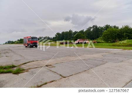 In this captivating scene, a state-of-the-art firetruck, equipped with advanced rescue technology, stands ready with its skilled firefighting team, prepared to intervene and respond rapidly to 127567067