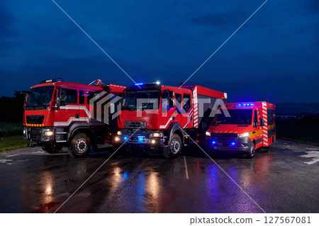 A pair of highly modern and quality fire trucks illuminate the night with their rotating lights, symbolizing the cutting-edge technology and preparedness of the firefighting fleet, ready to respond to A pair of highly modern and quality fire trucks illuminate the night with their rotating lights, symbolizing the cutting-edge technology and preparedness of the firefighting fleet, ready to respond to 127567081