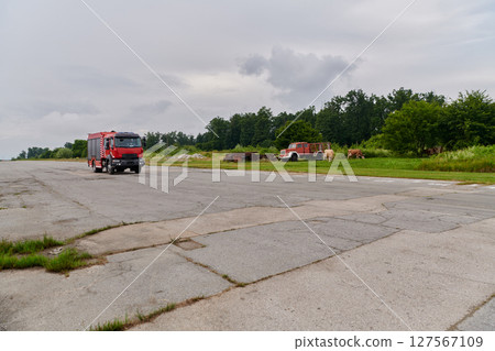 In this captivating scene, a state-of-the-art firetruck, equipped with advanced rescue technology, stands ready with its skilled firefighting team, prepared to intervene and respond rapidly to 127567109