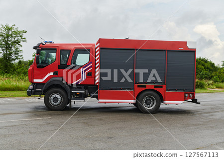 In this captivating scene, a state-of-the-art firetruck, equipped with advanced rescue technology, stands ready with its skilled firefighting team, prepared to intervene and respond rapidly to 127567113
