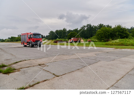 In this captivating scene, a state-of-the-art firetruck, equipped with advanced rescue technology, stands ready with its skilled firefighting team, prepared to intervene and respond rapidly to 127567117