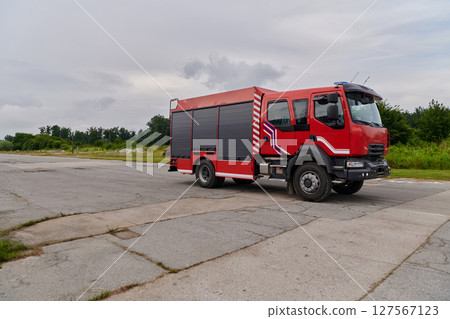 In this captivating scene, a state-of-the-art firetruck, equipped with advanced rescue technology, stands ready with its skilled firefighting team, prepared to intervene and respond rapidly to 127567123