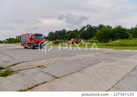 In this captivating scene, a state-of-the-art firetruck, equipped with advanced rescue technology, stands ready with its skilled firefighting team, prepared to intervene and respond rapidly to 127567129