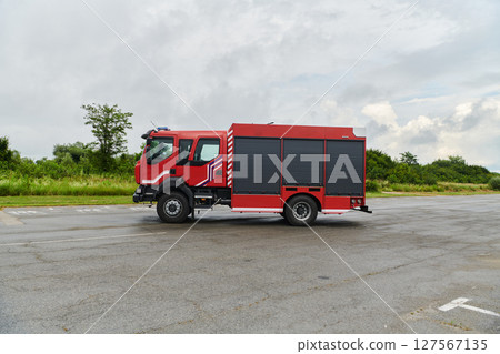 In this captivating scene, a state-of-the-art firetruck, equipped with advanced rescue technology, stands ready with its skilled firefighting team, prepared to intervene and respond rapidly to 127567135