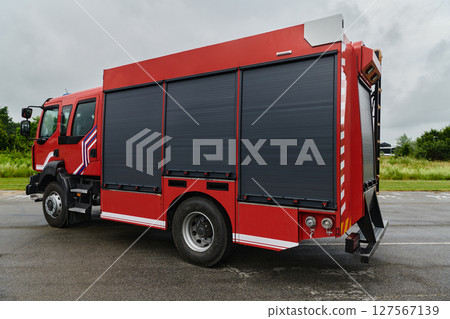 In this captivating scene, a state-of-the-art firetruck, equipped with advanced rescue technology, stands ready with its skilled firefighting team, prepared to intervene and respond rapidly to 127567139