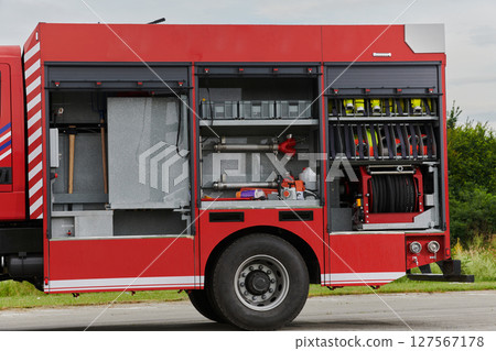In this captivating scene, a state-of-the-art firetruck, equipped with advanced rescue technology, stands ready with its skilled firefighting team, prepared to intervene and respond rapidly to 127567178