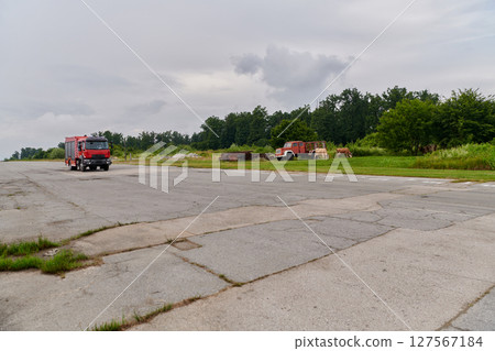 In this captivating scene, a state-of-the-art firetruck, equipped with advanced rescue technology, stands ready with its skilled firefighting team, prepared to intervene and respond rapidly to 127567184