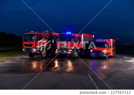 A pair of highly modern and quality fire trucks illuminate the night with their rotating lights, symbolizing the cutting-edge technology and preparedness of the firefighting fleet, ready to respond to A pair of highly modern and quality fire trucks illuminate the night with their rotating lights, symbolizing the cutting-edge technology and preparedness of the firefighting fleet, ready to respond to 127567212