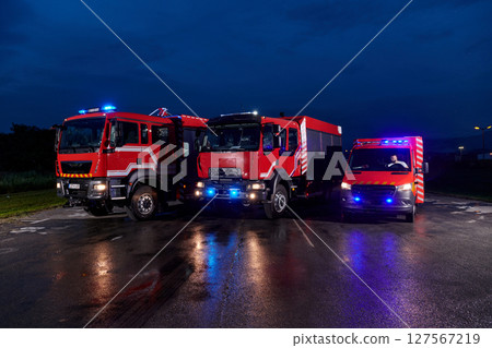 A pair of highly modern and quality fire trucks illuminate the night with their rotating lights, symbolizing the cutting-edge technology and preparedness of the firefighting fleet, ready to respond to A pair of highly modern and quality fire trucks illuminate the night with their rotating lights, symbolizing the cutting-edge technology and preparedness of the firefighting fleet, ready to respond to 127567219