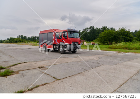 In this captivating scene, a state-of-the-art firetruck, equipped with advanced rescue technology, stands ready with its skilled firefighting team, prepared to intervene and respond rapidly to In this captivating scene, a state-of-the-art firetruck, equipped with advanced rescue technology, stands ready with its skilled firefighting team, prepared to intervene and respond rapidly to 127567223