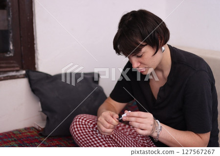 Young woman applying nail polish at home 127567267
