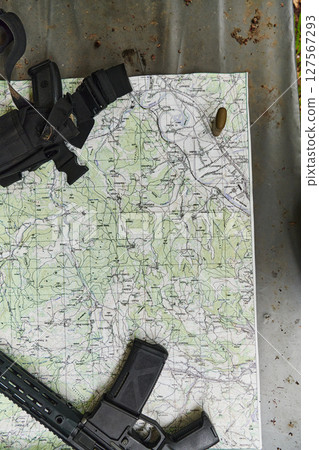 An array of military weapons, including rifles and pistols, is meticulously arranged on a table in a military base, presenting a close-up view of the diverse firepower and armament meticulously 127567293