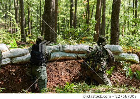 two elite soldiers stand guard, resolute and vigilant, defending the area against attacking enemies with tactical precision and unwavering determination, showcasing their role as skilled protectors in 127567302