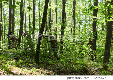 A specialized military antiterrorist unit conducts a covert operation in dense, hazardous woodland, demonstrating precision, discipline, and strategic readiness A specialized military antiterrorist unit conducts a covert operation in dense, hazardous woodland, demonstrating precision, discipline, and strategic readiness 127567322