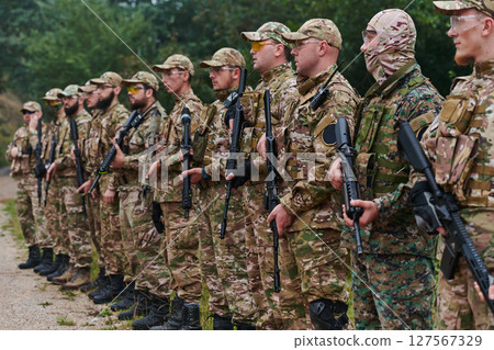 Soldier fighters standing together with guns. Group portrait of US army elite members, private military company servicemen, anti terrorist squad Soldier fighters standing together with guns. Group portrait of US army elite members, private military company servicemen, anti terrorist squad 127567329