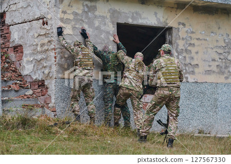 In a high stakes mission, a specialized military unit executes a tactical operation to secure a dangerous house where terrorists are believed to be hiding, showcasing precision and coordinated 127567330