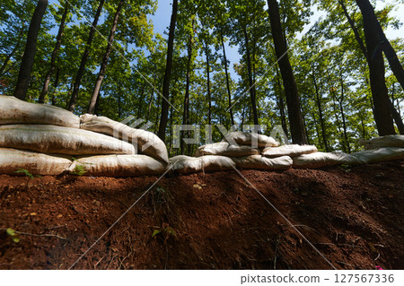 a military unit strategically employs sandbags as a defensive wall, creating a fortified barrier to enhance their safety and protection, showcasing the tactical use of simple yet effective measures 127567336