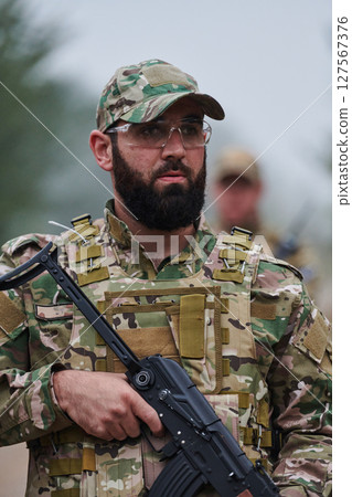 Elite soldier exudes focused determination and readiness, geared up for a perilous military operation, capturing the essence of courage and professionalism in the face of imminent danger 127567376