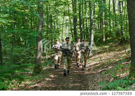 A specialized military antiterrorist unit conducts a covert operation in dense, hazardous woodland, demonstrating precision, discipline, and strategic readiness A specialized military antiterrorist unit conducts a covert operation in dense, hazardous woodland, demonstrating precision, discipline, and strategic readiness 127567389