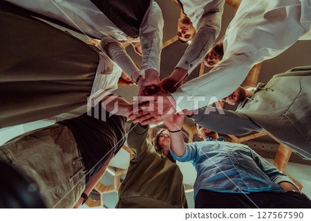 A group of young businessmen offer their hands together, symbolizing togetherness in the business world 127567590