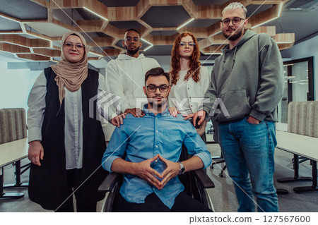 Young businessmen in a modern office extend a handshake to their business colleague in a wheelchair, showcasing inclusivity, support, and unity in the corporate environment. 127567600