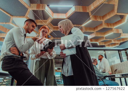 Young group of business people brainstorming together in a startup space, discussing business projects, investments, and solving challenges. Young group of business people brainstorming together in a startup space, discussing business projects, investments, and solving challenges. 127567622