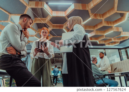 Young group of business people brainstorming together in a startup space, discussing business projects, investments, and solving challenges. Young group of business people brainstorming together in a startup space, discussing business projects, investments, and solving challenges. 127567624