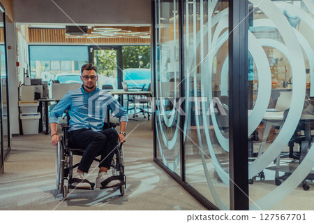 In a large modern corporation, a determined businessman in a wheelchair navigates through a hallway, embodying empowerment and inclusivity in the corporate world. 127567701