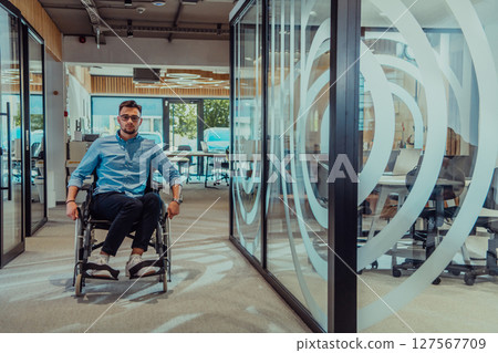 In a large modern corporation, a determined businessman in a wheelchair navigates through a hallway, embodying empowerment and inclusivity in the corporate world. In a large modern corporation, a determined businessman in a wheelchair navigates through a hallway, embodying empowerment and inclusivity in the corporate world. 127567709