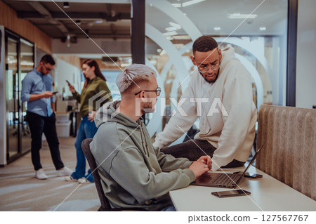Young group of business people brainstorming together in a startup space, discussing business projects, investments, and solving challenges. Young group of business people brainstorming together in a startup space, discussing business projects, investments, and solving challenges. 127567767