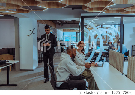 Young group of business people brainstorming together in a startup space, discussing business projects, investments, and solving challenges. 127567802