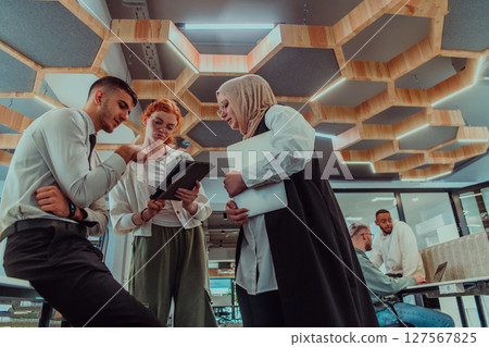 Young group of business people brainstorming together in a startup space, discussing business projects, investments, and solving challenges. 127567825