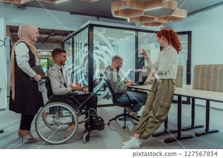 Young group of business people brainstorming together in a startup space, discussing business projects, investments, and solving challenges. 127567854