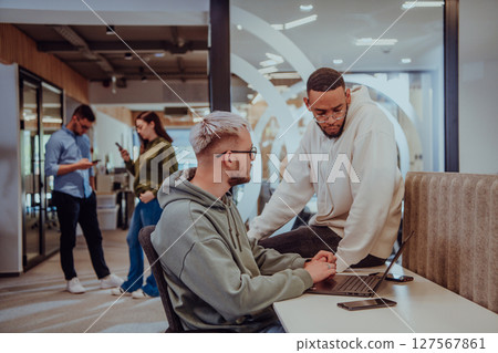 Young group of business people brainstorming together in a startup space, discussing business projects, investments, and solving challenges. 127567861