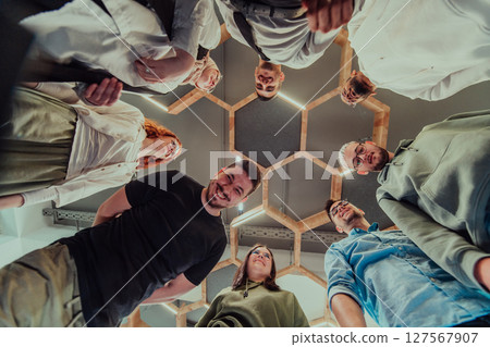 A group of young businessmen offer their hands together, symbolizing togetherness in the business world A group of young businessmen offer their hands together, symbolizing togetherness in the business world 127567907