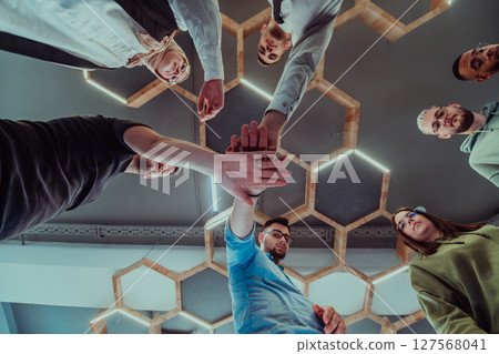 A group of young businessmen offer their hands together, symbolizing togetherness in the business world 127568041