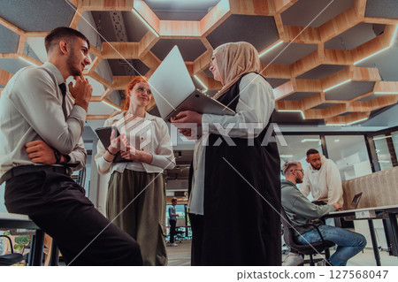 Young group of business people brainstorming together in a startup space, discussing business projects, investments, and solving challenges. Young group of business people brainstorming together in a startup space, discussing business projects, investments, and solving challenges. 127568047