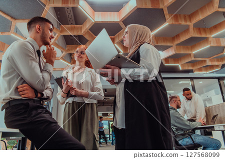 Young group of business people brainstorming together in a startup space, discussing business projects, investments, and solving challenges. 127568099